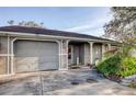 Charming single-Gathering home features a manicured lawn, a gray exterior, and an attached two-car garage at 5741 Riddle Rd, Holiday, FL 34690