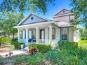 Inviting home featuring a quaint front porch with elegant columns, framed by verdant, meticulously maintained landscaping at 6002 Churchside Dr, Lithia, FL 33547