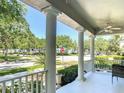 Covered front porch featuring classic white columns and railings, offering a serene view of the neighborhood at 6002 Churchside Dr, Lithia, FL 33547