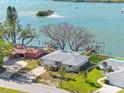 Stunning waterfront home with a private dock, surrounded by lush greenery and clear blue waters at 7160 S Shore S Dr, South Pasadena, FL 33707