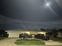 Night view of home featuring a two-car garage and mature landscaping at 731 Snug Is, Clearwater, FL 33767