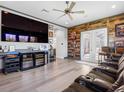 Entertainment room featuring a large screen TV, beverage cooler, hardwood floors, and comfortable theater-style seating at 7415 Paradiso Dr, Apollo Beach, FL 33572
