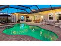 Inviting backyard pool with spa, covered lanai, outdoor kitchen, and comfortable seating at 7415 Paradiso Dr, Apollo Beach, FL 33572