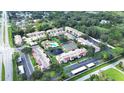 Aerial view of the community with a pool, tennis court, pond, green spaces, and mature trees at 9700 Starkey Rd # 321, Seminole, FL 33777