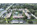 Aerial community view showcasing manicured lawns, swimming pool, tennis courts and surrounding greenery at 9700 Starkey Rd # 321, Seminole, FL 33777
