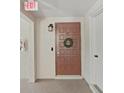 Condo entrance featuring a decorative wreath, updated lighting, and secure entry system at 9700 Starkey Rd # 321, Seminole, FL 33777