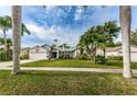 Inviting single-Gathering home showcasing lush green lawn and mature palm trees at 1031 Ridge View Ln, Palm Harbor, FL 34683