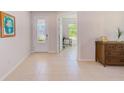 Bright foyer with tile flooring, decorative front door, and view of adjacent home office at 11086 Sundrift Dr, Tampa, FL 33647