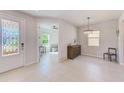 Welcoming foyer with decorative door, tile flooring, and view of the den with fan at 11086 Sundrift Dr, Tampa, FL 33647