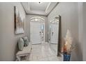 Bright entryway with tile flooring, neutral paint, and a decorative mirror and bench, creating an inviting space at 13325 Sunset Shore Cir, Riverview, FL 33579