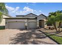 Beautiful home exterior featuring a brick driveway, manicured lawn, and a two-car garage, perfect for curb appeal at 13325 Sunset Shore Cir, Riverview, FL 33579