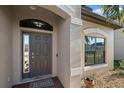 Welcoming front door with sidelight and decorative window above, set against a backdrop of stone landscaping at 13325 Sunset Shore Cir, Riverview, FL 33579