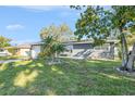 Charming single-story home with a well-manicured lawn and mature trees at 1424 Orange St, Clearwater, FL 33756