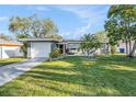 Charming single-story home with a well-manicured lawn and a two-car garage at 1424 Orange St, Clearwater, FL 33756