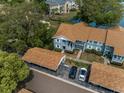 An aerial view of the condo with assigned covered parking spaces, landscaping, and blue sky above at 1438 Millstream Ln # 201, Dunedin, FL 34698