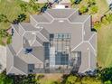 Aerial view of a unique estate showing the screen enclosed in-ground pool and intricate roof design at 19005 Cour Ests, Lutz, FL 33558