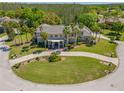 Aerial view of a luxurious residence, showcasing its meticulously landscaped grounds and inviting circular driveway at 19005 Cour Ests, Lutz, FL 33558