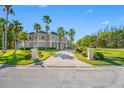Beautiful home exterior featuring lush lawn, mature landscaping and a circular paver driveway at 19005 Cour Ests, Lutz, FL 33558