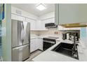 Bright kitchen with white cabinets, stainless steel refrigerator, and modern appliances, creating a clean, contemporary space at 1901 66Th N Ave, St Petersburg, FL 33702