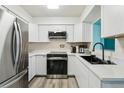Bright kitchen features stainless steel appliances, white cabinets, and a black sink with modern fixtures at 1901 66Th N Ave, St Petersburg, FL 33702