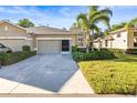 Exterior shot of a home showing a concrete driveway leading to a two-car garage at 1922 Sifield Greens Way # 47, Sun City Center, FL 33573