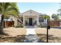 Inviting home with a lovely porch, complemented by a lush palm tree and a neat, green lawn at 205 N Westland Ave, Tampa, FL 33606