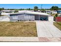 Charming single-story home with a gray exterior, white trim, well-maintained lawn, and inviting outdoor seating at 21298 Austin Ave, Port Charlotte, FL 33952