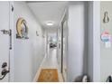 A bright hallway with a sliding door closet, tile flooring, and decorative wall hangings at 2699 Seville Blvd # 805, Clearwater, FL 33764