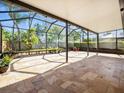 Large screened patio features travertine flooring, offering ample space for outdoor dining and relaxation at 5117 Brynn Mawr Dr, Tampa, FL 33624