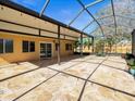 Spacious screened lanai with travertine tile floors, seamlessly connected to the home's interior at 5117 Brynn Mawr Dr, Tampa, FL 33624