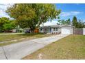 Single-story home with a long driveway, attached garage, mature landscaping, and welcoming curb appeal at 5261 43Rd N Ave, St Petersburg, FL 33709