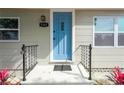 Home entryway features a stylish blue front door, black railings, manicured landscaping, and visible house number at 5261 43Rd N Ave, St Petersburg, FL 33709
