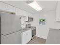 Bright kitchen with white cabinets, stainless steel appliances, subway tile backsplash, and wood-look floors at 5261 43Rd N Ave, St Petersburg, FL 33709