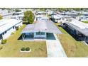 Aerial view of a cozy mobile home featuring a covered carport and well-kept surroundings in a serene neighborhood at 5306 Mary St, Zephyrhills, FL 33542