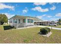 Inviting mobile home showcasing a lovely front yard and covered porch, perfect for relaxing in a quiet setting at 5306 Mary St, Zephyrhills, FL 33542