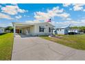 Welcoming home featuring a spacious driveway, convenient carport, and a well-kept front yard at 5745 Pawnee St, Zephyrhills, FL 33542