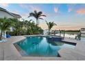 Stunning backyard oasis featuring a pool, spa, and beautiful landscaping with waterfront views at 6113 Pasadena Point Blvd, Gulfport, FL 33707