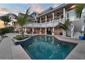 Inviting swimming pool with palm trees and covered patio for outdoor entertaining at 6113 Pasadena Point Blvd, Gulfport, FL 33707