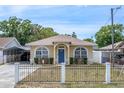 A well maintained single-story home featuring a fenced yard, blue door, arched windows at 6920 N Hubert Ave, Tampa, FL 33614
