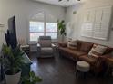 Cozy living room with wood floors, comfortable seating, and natural light from shuttered windows at 6920 N Hubert Ave, Tampa, FL 33614