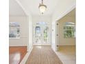 Inviting home foyer with decorative glass double doors, tile flooring, and a neutral-toned rug at 6968 De Brita Rd, North Port, FL 34291