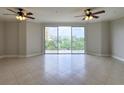 Spacious living area with tile flooring, ceiling fans, and sliding glass doors to a balcony with a view at 750 4Th S Ave # 603C, St Petersburg, FL 33701
