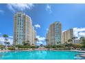 Luxury resort-style pool with towering condo buildings and lush tropical landscaping at 1180 Gulf Blvd # 1201, Clearwater, FL 33767