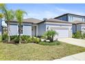 Well-maintained single-Gathering home with beautiful landscaping, a two-car garage, and a walkway to the entrance at 14180 Samoa Hill Ct, Riverview, FL 33569