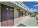 Street-side view of condo showcasing charming exterior, light-colored stucco walls, and welcoming front door at 1801 Bedford Ter # 221, Sun City Center, FL 33573