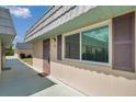Side-angle view of condo, highlighting the walkway, window with shutters, and neutral color scheme at 1801 Bedford Ter # 221, Sun City Center, FL 33573