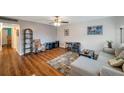 Cozy living room with hardwood floors, comfortable sectional sofa, ceiling fan, and decorative rug at 1801 Bedford Ter # 221, Sun City Center, FL 33573