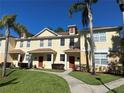Inviting townhomes with manicured lawns, mature palms, and walkway to front doors at 2061 Fiesta Ridge Ct, Tampa, FL 33604
