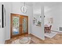 Elegant entryway featuring decorative glass double doors, tile flooring, and stylish light fixture at 3267 Westcott Ct, Palm Harbor, FL 34684