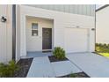 Inviting exterior of a well-maintained townhome featuring a gray door with wreath and attached garage at 4326 Banjo Lake Rd, Land O Lakes, FL 34639